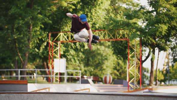 Aggressive Inline Roller Skater Doing Tricks in Concrete Skatepark Outdoors with Beautiful