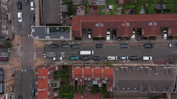 Aerial Birds Eye Overhead Top Down Tracking of White Delivery Van Driving in Street of Town and