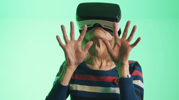 Old Caucasian Woman with VR Headset Touching the Air