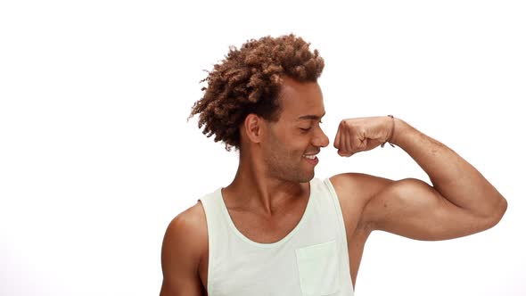Man Smiling Showing Muscles Pointing Finger Up Over White Background Slow Motion