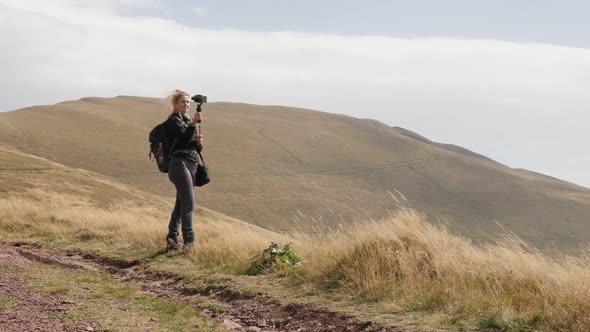 Slow motion of female hiker who  takes selfies on mountain peak close-up 1080p FullHD footage - Woma