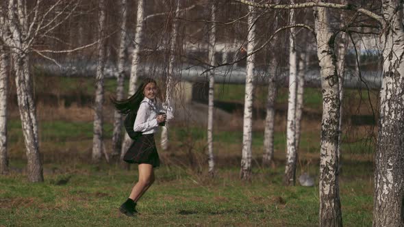 Laughing Chinese Female in Short Skirt Jumping Along the Field To Girl's Picnic