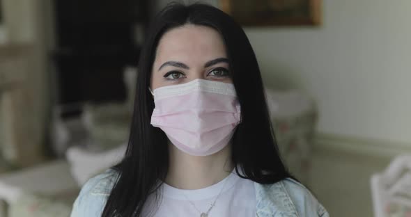 Girl in Surgical Mask for Virus Prevention Looks at Camera in Isolated Home