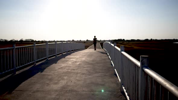 Silhouette woman running on the bridge