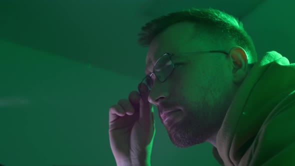 A Caucasian Man in Glasses Works on the Computer Types Checks the Information Coding Studying