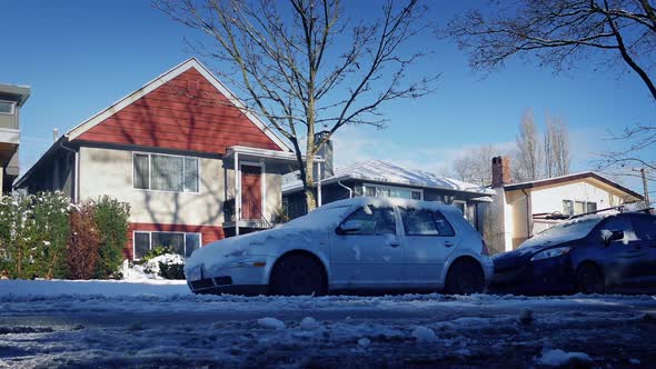 Passing Parked Cars By Houses In The Snow