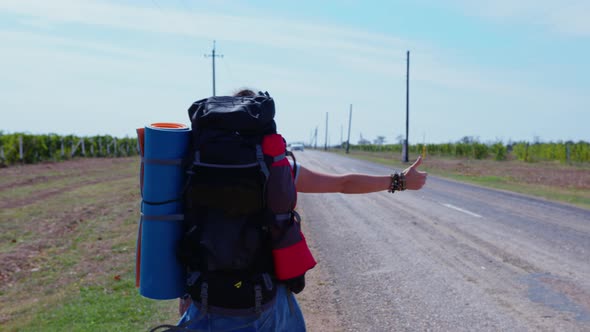 Female Hitchhiker Backpacker Hiker on Roadside