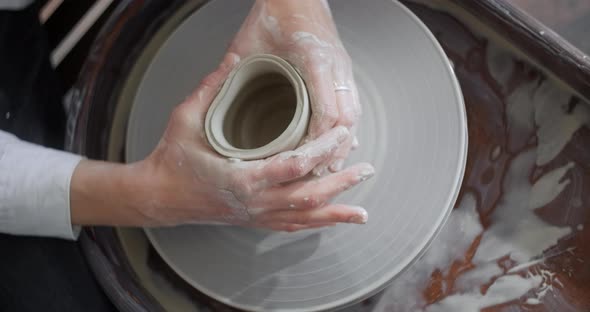 Top View Ceramist Sculpts a Jug on a Potter's Wheel Video From Pottery Workshop Potter Makes