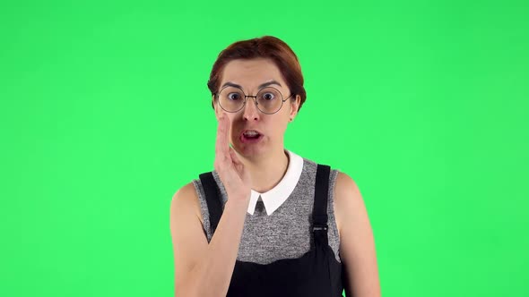 Portrait of Funny Girl in Round Glasses Is Screaming Calling Someone. Green Screen