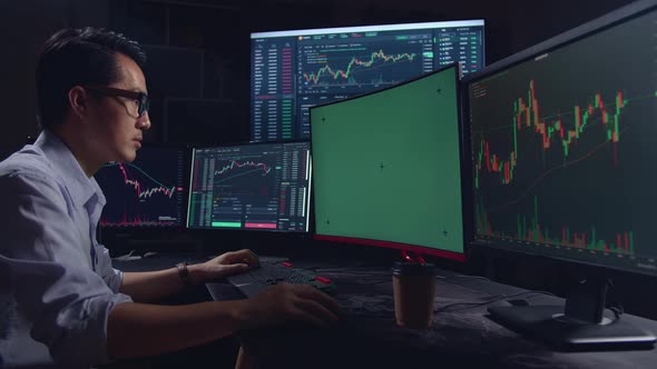 Trader Working On A Computer With Isolated Mock-Up Green Screen And Analyzing Graphs