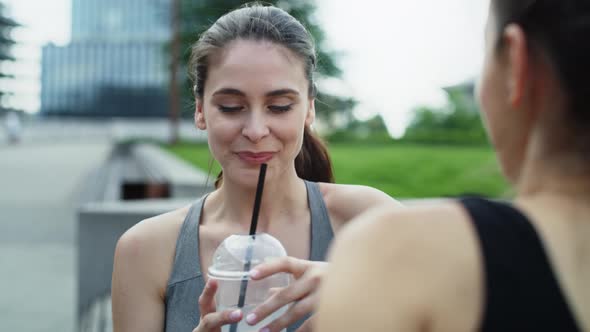 Video of women in training clothes talking and drinking water. Shot with RED helium camera in 8K.