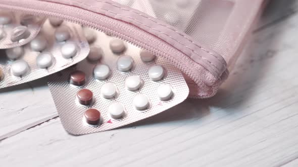 Birth Control Pills on Wooden Background Close Up