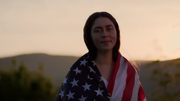 Smiling woman turn around and draping an American flag over her shoulders