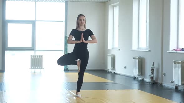 Yoga girl student in Studio. a woman meditates in a balance pose in yoga Studio