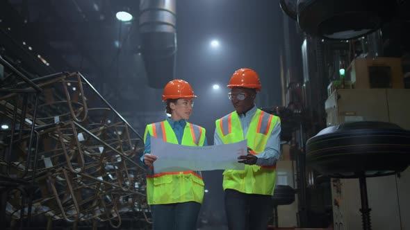 Supervisor Partners Discussing Plan Wearing Safety Uniform at Huge Warehouse