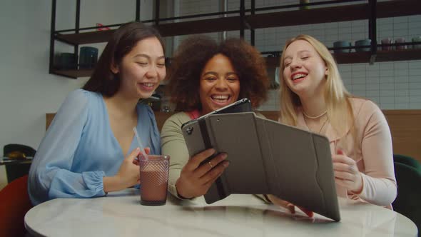 Multiracial Women Browsing Online Content on Tablet Pc at Cafe