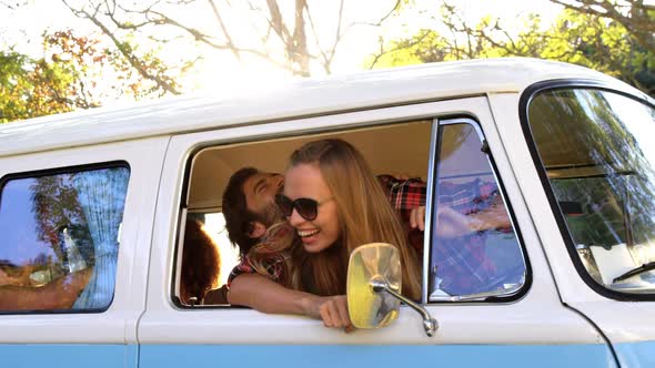 Hipster couple looking out of window of the van