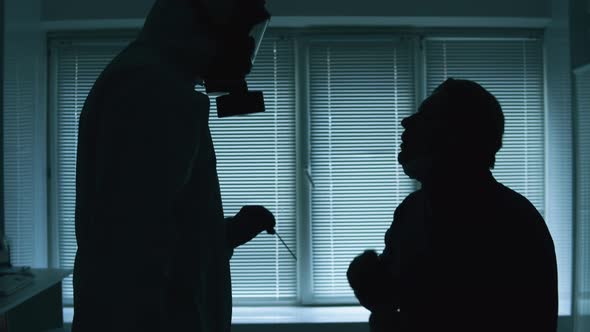 Patient is Getting His Throat Tested in a Dark Clinic Ward