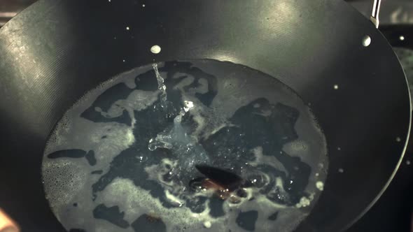 Super Slow Motion Mussels Fall Into a Hot Frying Pan for Cooking