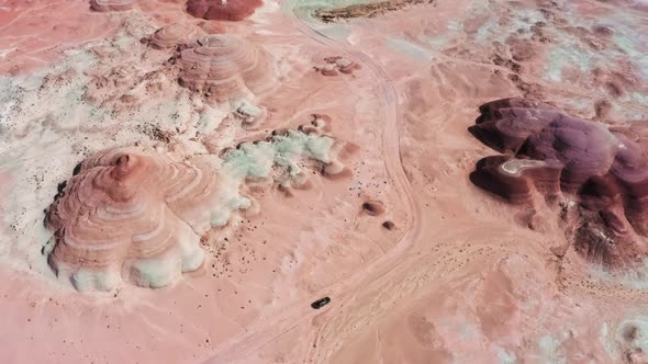 Distant Aerial View Car Driving By Red Mars with Colorful Wavy Hills Formations