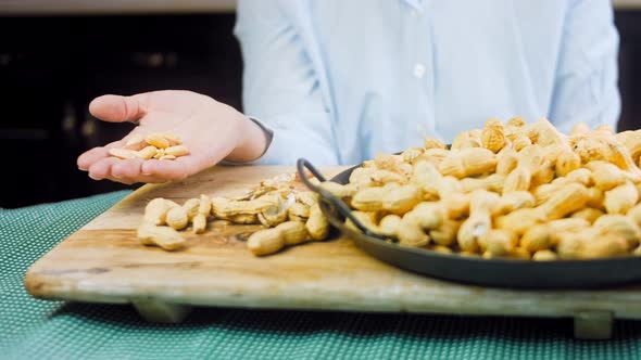 The Woman Peels the Peanuts From the Retro Tray