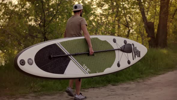 Tourist Carries Sup Board On Vacation. Tourist Floating Standup Paddle Board.
