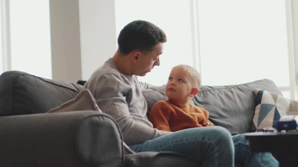 Serious father talking with his little son