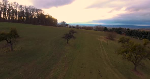 Drone flight over hill at noon.