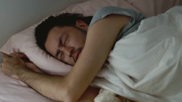 Sleeping Asian man bad dreaming anxious in the bedroom at home.