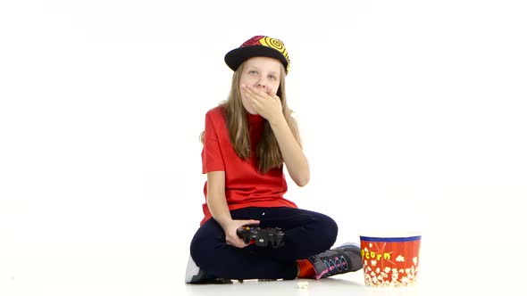 Girl Plays with Joystick in Online Game and Eats Popcorn alt