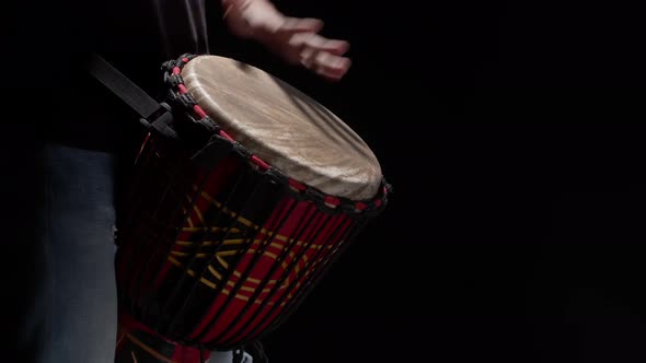 Black Man Plays Drum with Hands Closeup in Studio