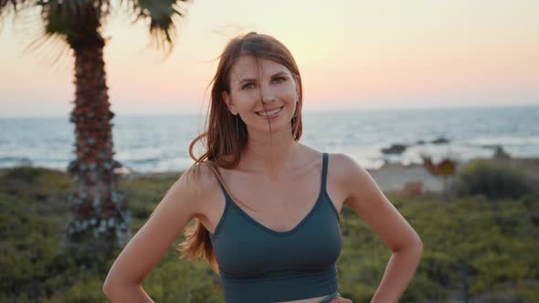 Woman in Sportswear Taking Break During Exercises on Beach