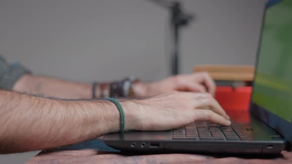 Hairy Hands Typing in a Computer with a Green Screen