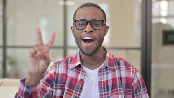 Portrait of African Man Showing Victory Sign with Finger