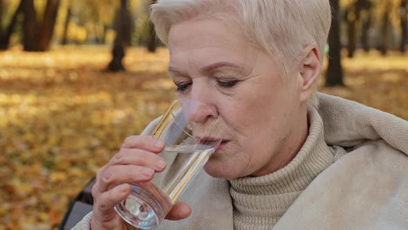 Closeup Happy Elderly Woman Drinking Glass of Fresh Pure Filtered Water Maintains Balance Smiling