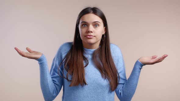 Young Indifferent Unsure Woman Makes Gesture of I Don't Know Can't Help Anything