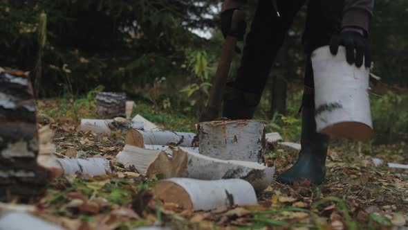 Young handsome man chops wood in the forest. 