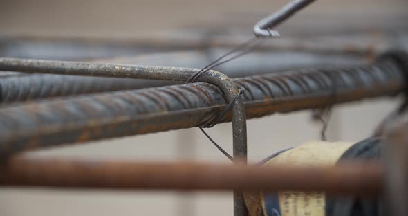 Close Up of a Worker Securing the Metal Rods with Wire Construction Site