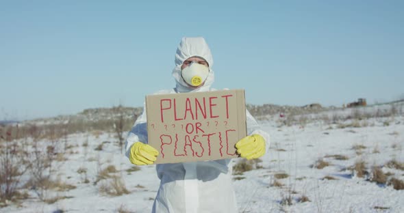 Man Wore in Cover Suit Shows Protest Sign Planet or Plastic at Camera