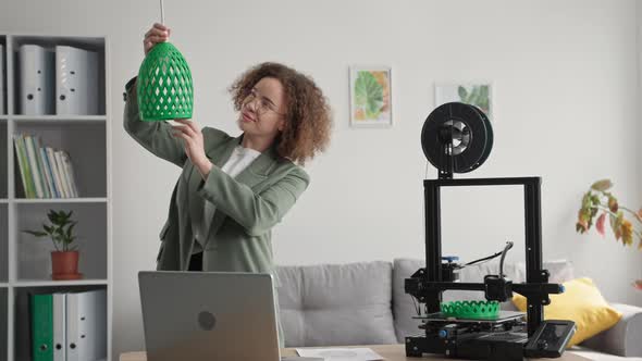 Portrait of Young Woman Using 3D Printed Lamp Shade Model Printed on 3D Printer for Home Improvement