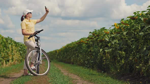 Woman Cyclist Catches a Phone Signal in Nature