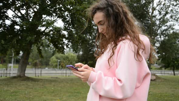 Beautiful Girl Writes a Message on Her Smartphone