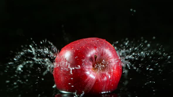 Super Slow Motion Shot of Fresh Red Apple Falling Into Water on Black Background at 1000Fps.