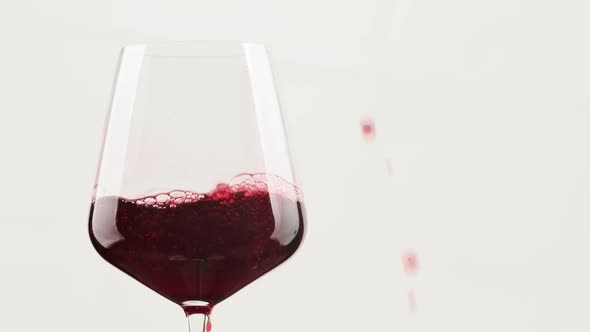 Red Wine Pouring in Wine Glass at Dark Background