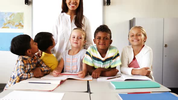 Portrait of teacher and school kids in classroom