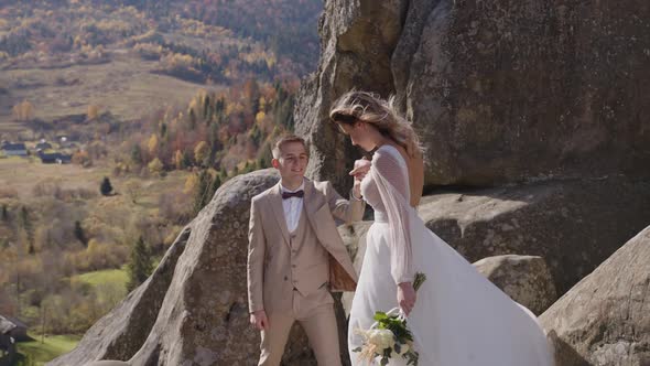 Majestic View of Rock Mountain and Beautyiful Newlyweds Who Approach to Each Other