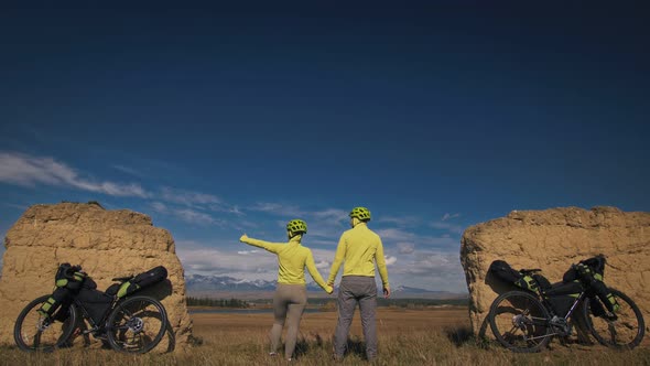 The Man and Woman Travel on Mixed Terrain Cycle Touring with Bikepacking. The Two People Journey