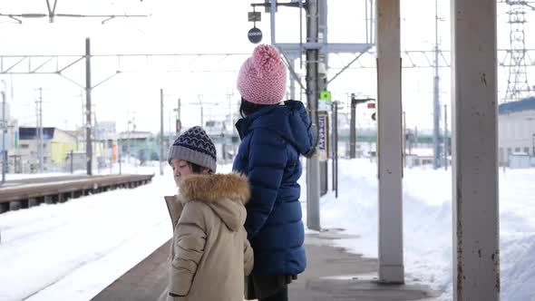 Asian Children Waiting Express Train On Railway Station Platform,Winter Travel Concept 