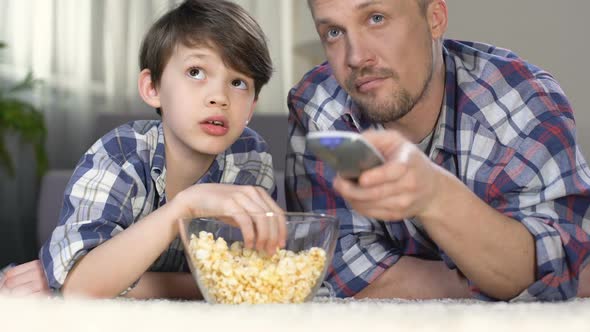 Male Company Spending Time Together Watching Tv and Eating Popcorn, Fatherhood