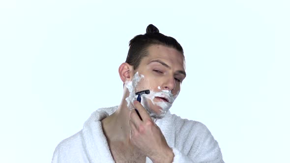 Man Shaves Stubble with Razor Blade. White Background. Slow Motion